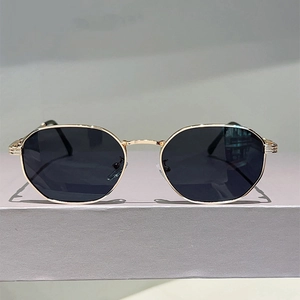 Detailed view of vintage gold metal frame sunglasses with black geometric lenses on a stand