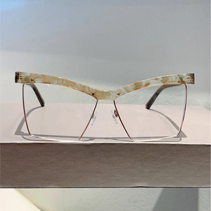 Detailed shot of cat-eye square glasses with marble texture frames and gold metal accents
