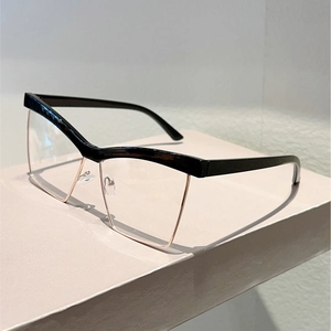 Detail view of cat eye glasses with black semi-rimless brow and gold metal frame finish