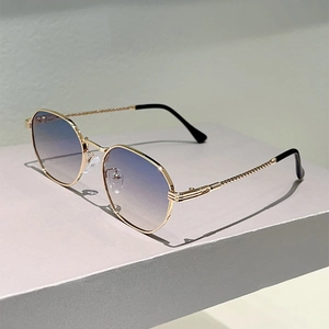 Detail of gold metal frame sunglasses with braided temples and gradient lenses