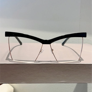 Detail of cat-eye square frame with black top rim and gold metal lower bridge