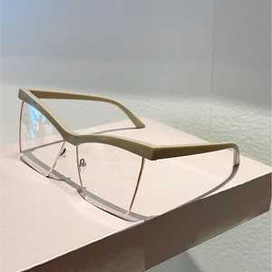 Detail of stylish oversized square glasses with beige top frame and rose gold metal legs