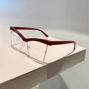 Detail of red and gold cat-eye half-frame glasses with smooth metallic finish