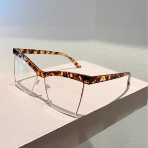 Macro detail of cat-eye frames with leopard print acetate and light gold metal rims