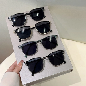 Detail of four retro semi-rimless sunglasses in black, gold, silver and cyan metal colors