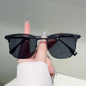Detailed view of hand-held vintage retro square semi-rimless sunglasses with dark lenses