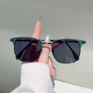 Detailed view of retro semi-rimless sunglasses with dark green frame and silver metal bridge