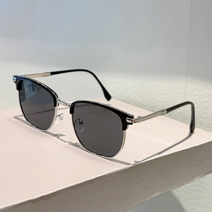 Close-up of retro semi-rimless sunglasses with silver metal frame and dark lenses