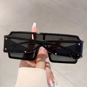 Gros plan sur des lunettes de soleil carrées noires futuristes avec rivets argentés