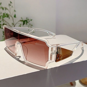 Détail de lunettes de soleil futuristes avec verres dégradés marron sur un support blanc