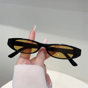 Gros plan de lunettes de soleil ovales rétro avec monture noire et verres jaune ambré
