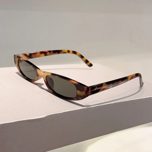 Gros plan de lunettes de soleil ovales vintage à motif léopard sur socle gris