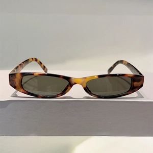 Détail de lunettes de soleil ovales rétro en écaille de tortue avec verres gris foncé