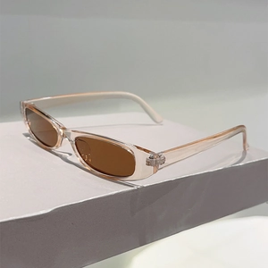 Détail de lunettes de soleil ovales rétro avec monture pêche et verres marron