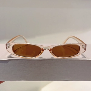 Vue détaillée de lunettes de soleil ovales roses transparentes avec verres teintés marron
