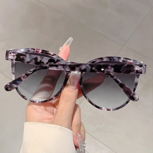Detail of purple marble cat-eye frame with grey gradient lenses and rhinestone accents