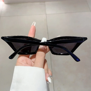 Détail de lunettes de soleil œil-de-chat noires vintage avec strass élégants sur le bord