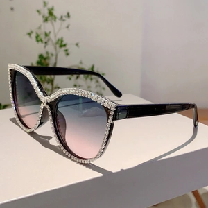 Cat eye rhinestone oversized sunglasses with blue pink gradient lenses on white stand