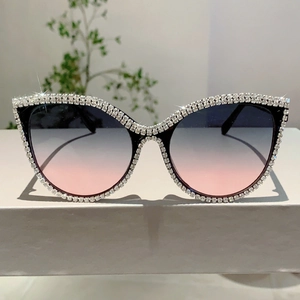 Close-up of cat-eye sunglasses with rhinestone-encrusted frames and gradient lenses