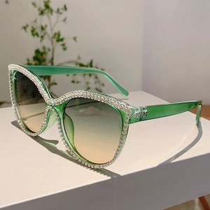 Detailed view of green cateye sunglasses with crystal rhinestones and gradient lenses