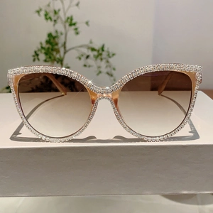 Detail of cat-eye sunglasses with rhinestone-encrusted frames and gradient lenses