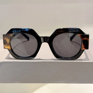 Detail of round thick-frame sunglasses with bicolor black and tortoise hinge accents