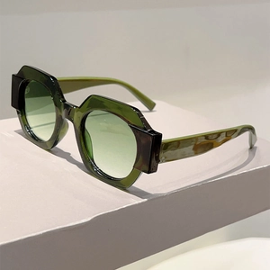 Detail of olive green translucent geometric frame and gradient lenses on sunglasses