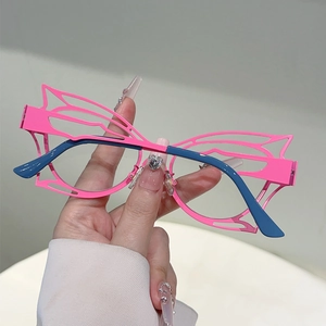 Detail of pink butterfly frame glasses with hollow cutout design and blue temples