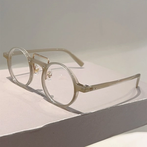 Détail d'une monture de lunettes ronde champagne avec double pont métallique rétro