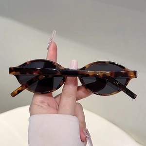 Détail macro de lunettes de soleil ovales rétro avec monture écaille et verres noirs