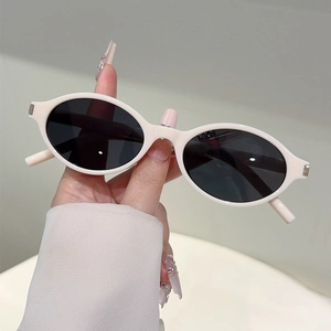 Détail de lunettes de soleil ovales beiges vintage avec verres foncés et accents