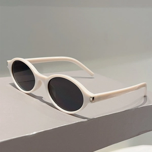 Détail de lunettes de soleil ovales blanches avec charnière métallique et verres noirs