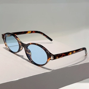 Détails de lunettes de soleil ovales en écaille avec verres bleu clair exposées
