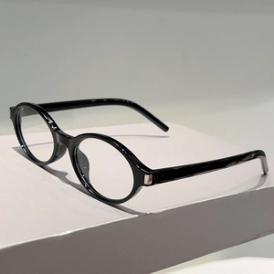Détail de lunettes de soleil ovales vintage avec monture noire brillante et charnières