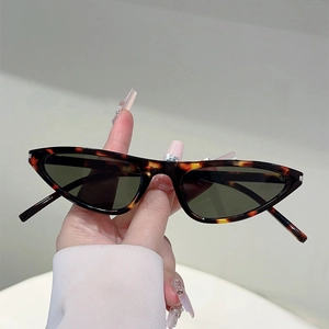 Detail der Dreieck-Cateye-Sonnenbrille mit Schildpatt-Rahmen und dunkelgrünen Gläsern