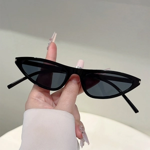 Detailansicht handgehaltener schwarzer schmaler Katzenaugen-Sonnenbrille mit Gläsern