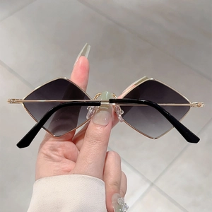 Detail of diamond-shaped sunglasses with gradient grey lenses and gold metal frames