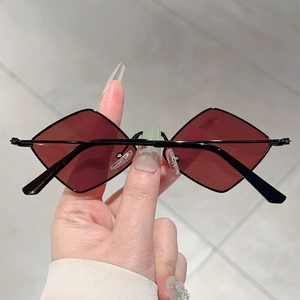 Detailed close-up of dark red geometric lenses and thin black metal frame sunglasses