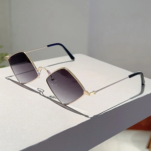 Close-up of gold metal sunglasses with geometric diamond-shaped gradient grey lenses