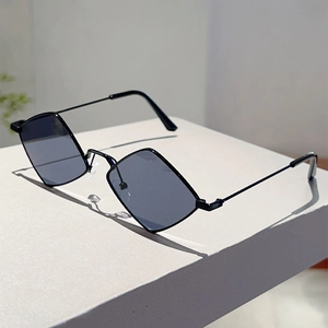 Detail view of stylish diamond-shaped lenses and thin black metal frame on a white block