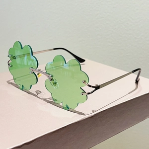 Detalle de las gafas de sol de trébol verde sin montura con marco de metal plateado