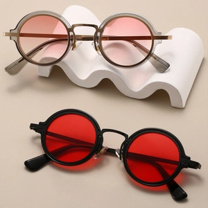 Retro round steampunk sunglasses with pink and red lenses on a minimalist tray