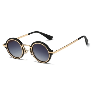 Detail view of round steampunk sunglasses with black and gold metal frame and gray lenses