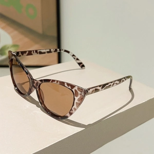 Close-up of retro cat-eye sunglasses with tortoise shell frames on a cream display