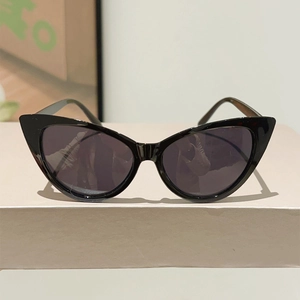 Close-up detail of vintage cat eye sunglasses with glossy black frame and dark grey lenses