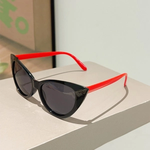 Detailed view of cat eye sunglasses with a black frame and vibrant red temples