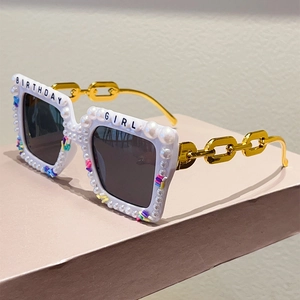 Detail of white Birthday Girl sunglasses with faux pearls and gold chain arms