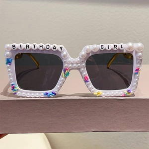 Detail of square birthday girl party sunglasses with white pearls and colorful sprinkles