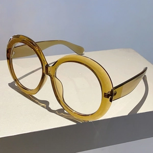 Detail of oversized amber resin glasses frames with transparent finish and artistic shadow