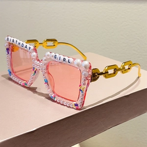 Detail of square pink party sunglasses with pearls and Birthday Girl lettering decoration